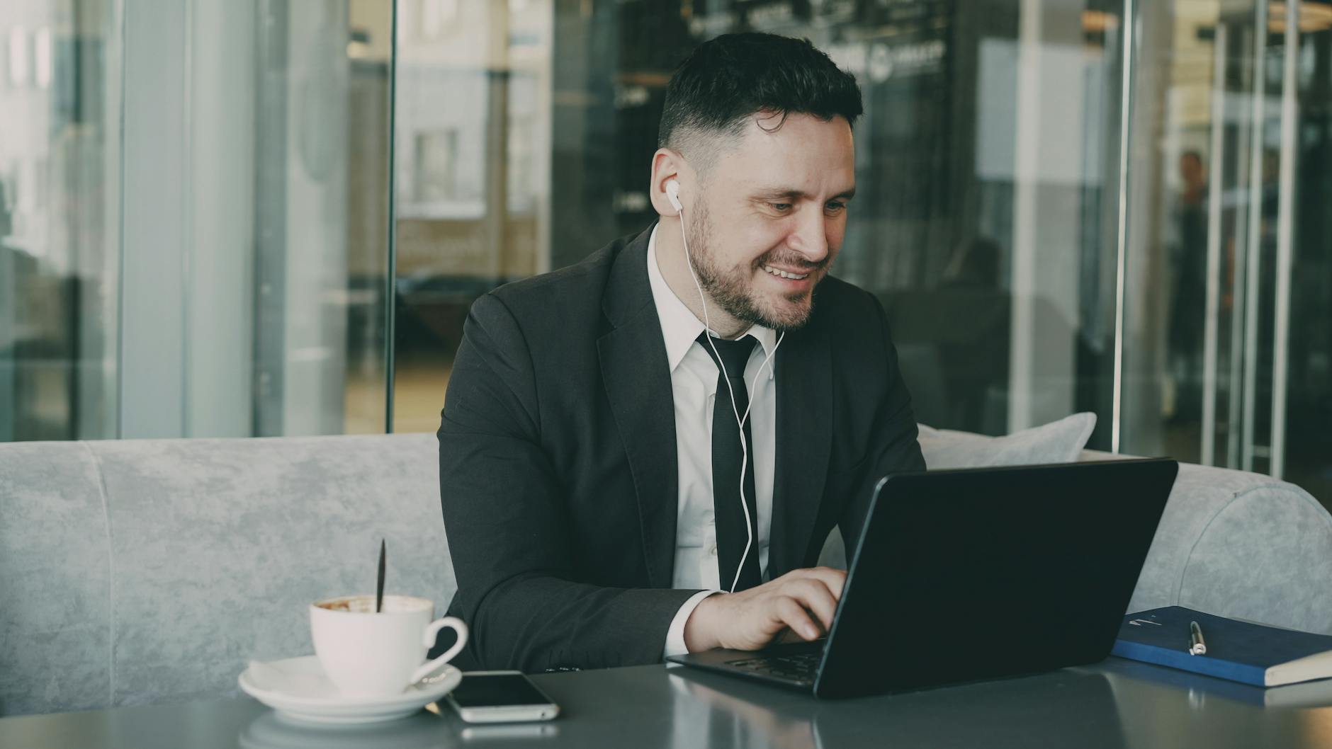 professional man working on laptop in modern cafe