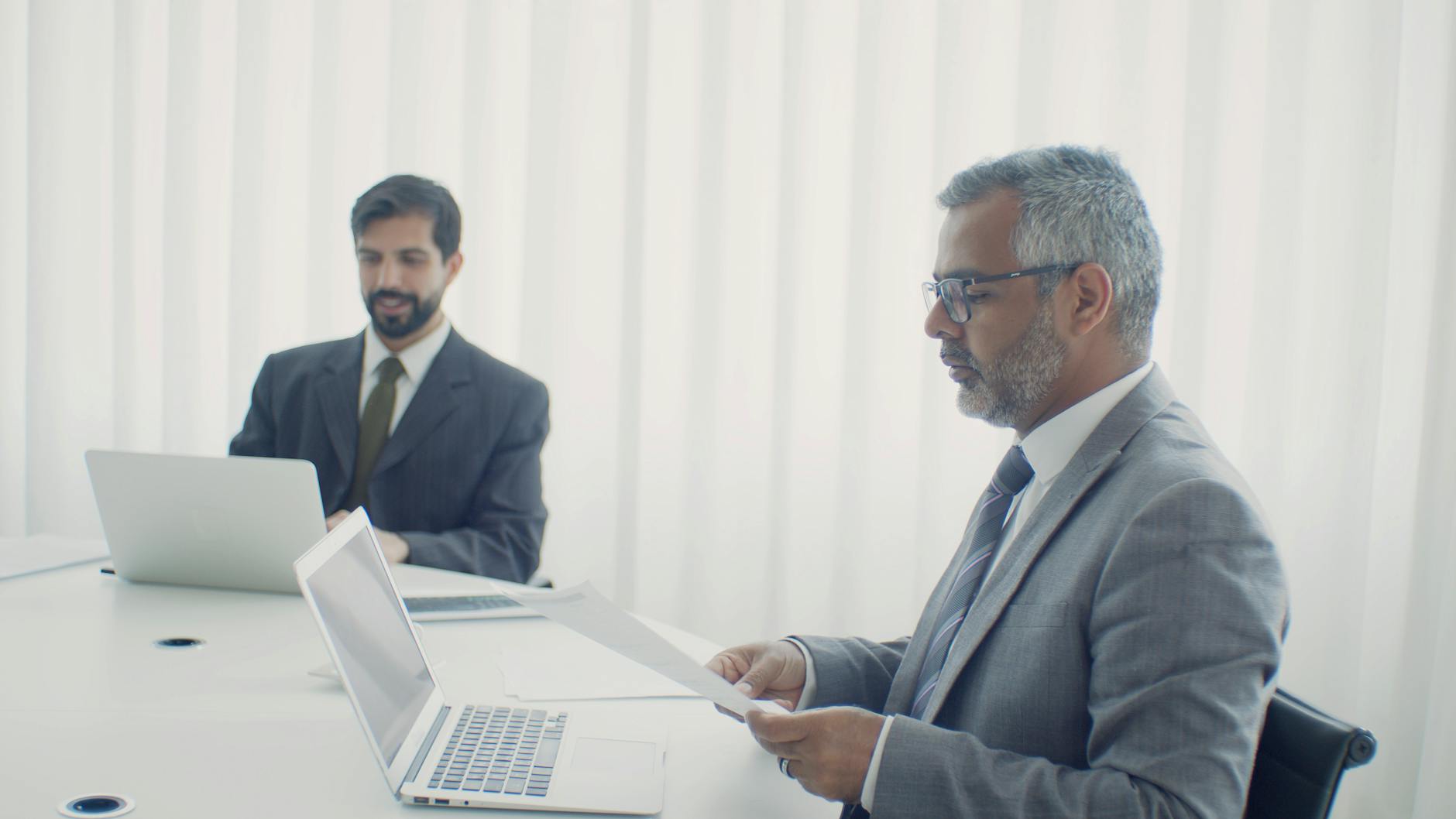 man in a suit reading a document